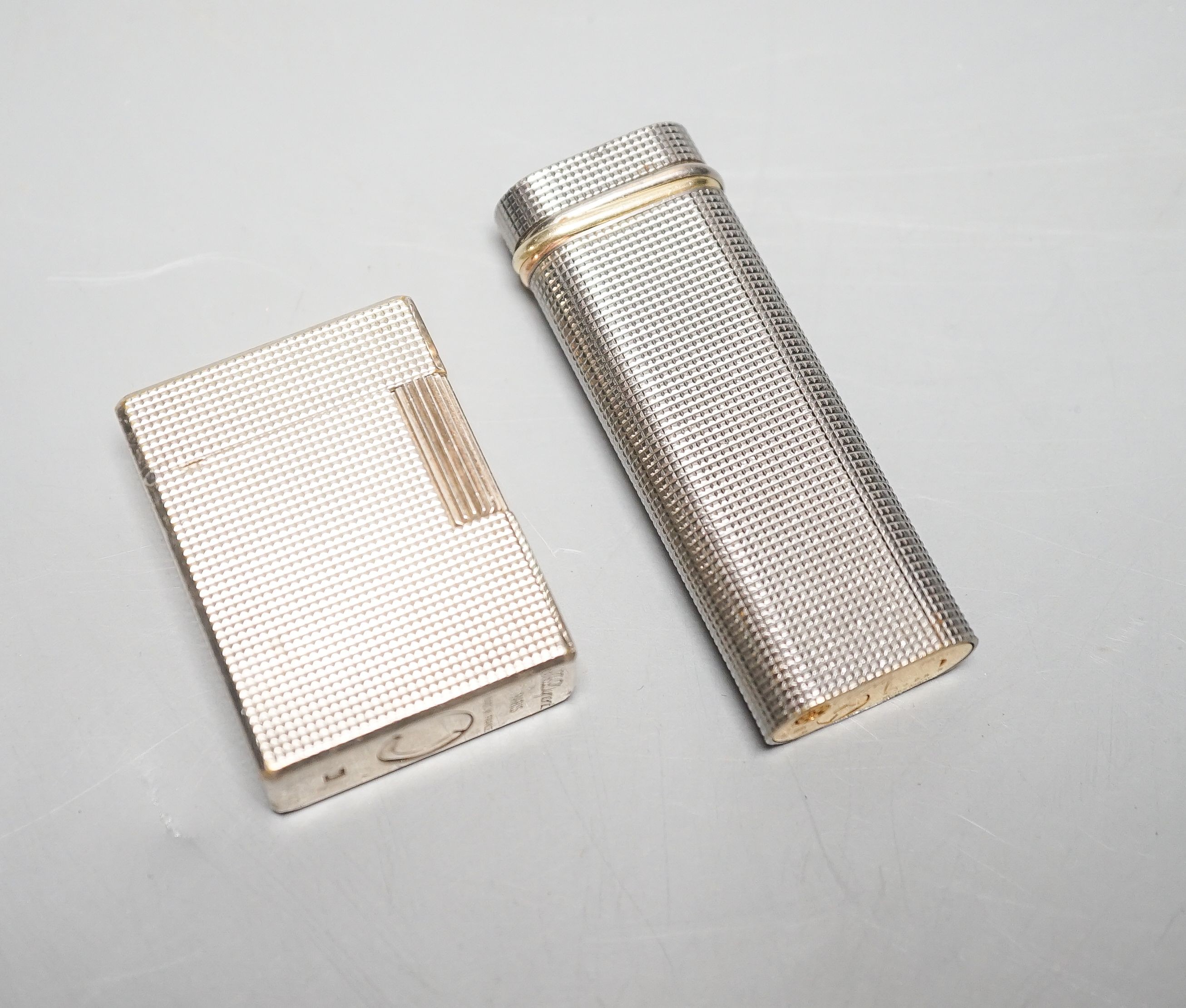 A Cartier engine turned lighter and a similar cased Dupont lighter